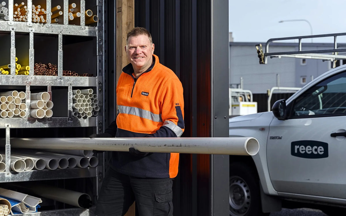 Reece employee wearing high-visibility fleece workwear, demonstrating work uniforms and injury prevention on-site with proper gear and handling.
