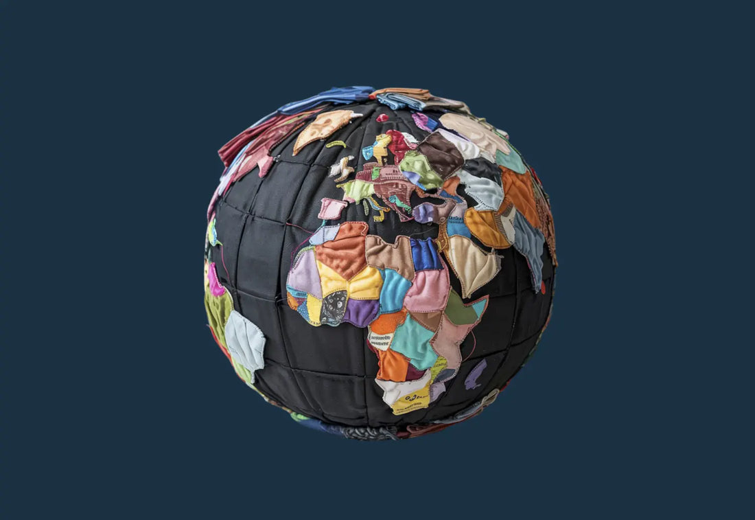 A globe made from colourful fabric scraps stitched together, symbolising global collaboration, ethical manufacturing, and sustainable textile practices in the uniform industry.