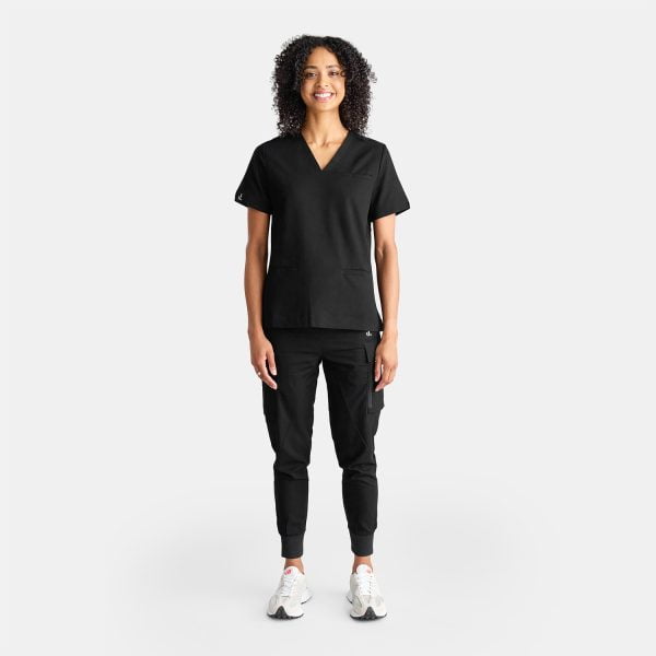 Full Body View of a Woman Wearing the Designs to You Midnight Black Scrubs. the Sleek Black Color Adds a Touch of Elegance to the Uniform, While the Comfortable Fit Allows for Ease of Movement. the Image Showcases the Modern Design and Attention to Detail of the Scrubs, Making Them a Perfect Choice for Healthcare Professionals Seeking Both Style and Functionality.