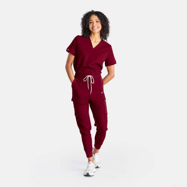 Full Body Photo Showcasing Our Cargo Pants' Pockets on a Female Healthcare Professional Confidently Wearing Vibrant Sangria Red Cargo Jogger Scrub Pant