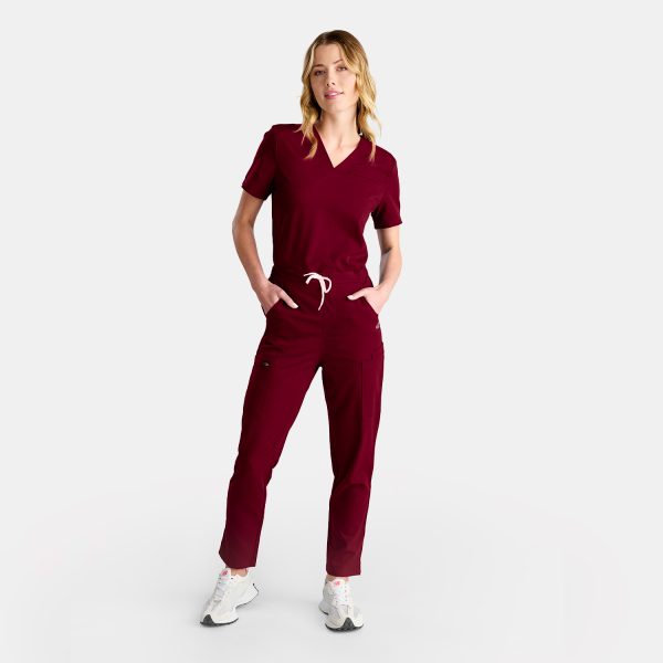 Full Body Image of a Female Healthcare Professional Wearing Vibrant Sangria Red Straight-leg Scrub Pants.