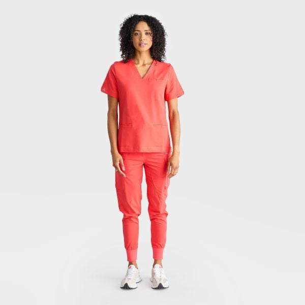 Full-body Image of a Woman Wearing the Designs to You Watermelon Scrubs. the Vibrant Watermelon Colour Adds a Pop of Freshness to the Uniform, While the Comfortable Fit Ensures Ease of Movement Throughout the Day. the Image Highlights the Stylish Design and High-quality Construction of the Scrubs, Making Them a Great Choice for Healthcare Professionals.
