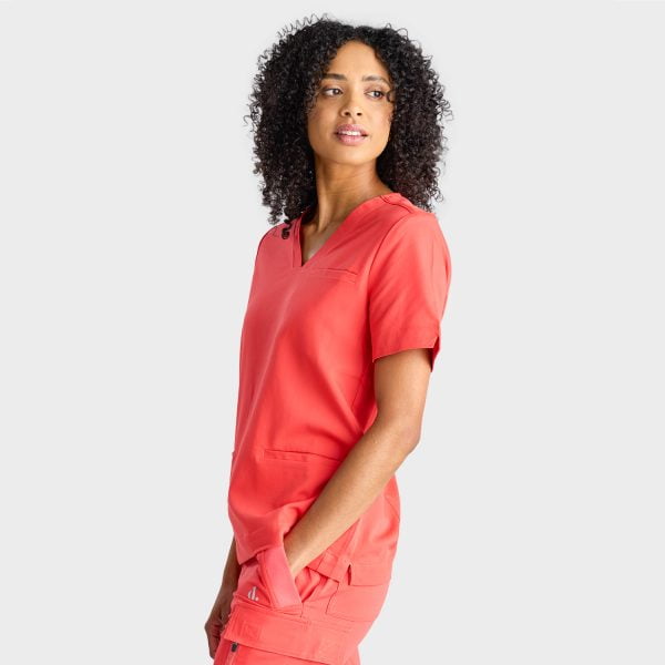 Side View of a Woman Wearing the Designs to You Watermelon Scrubs. the Vibrant Watermelon Colour Adds a Pop of Freshness to the Uniform, While the Comfortable Fit Ensures Ease of Movement Throughout the Day. the Image Highlights the Stylish Design and High-quality Construction of the Scrubs, Making Them a Great Choice for Healthcare Professionals.