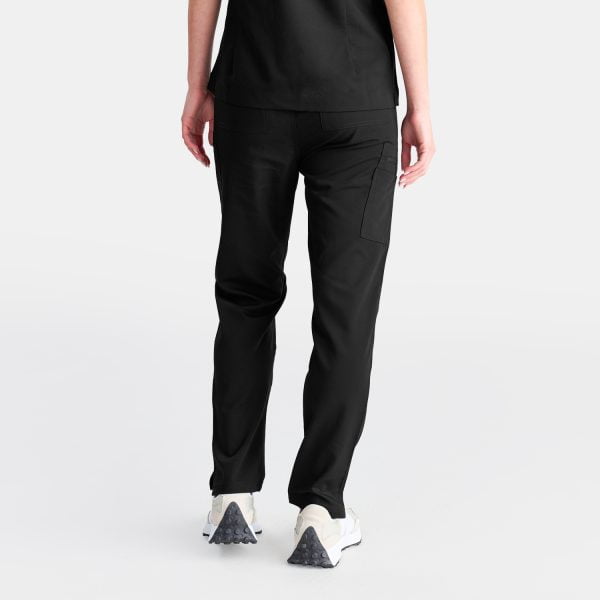 Back View of a Woman Wearing Designs to You Midnight Black Modern Scrub Pants and Our Modern Scrub Top. the Pants Feature a Stylish Straight Leg Design and Five Deep Pockets, Combining Functionality with a Sleek Aesthetic