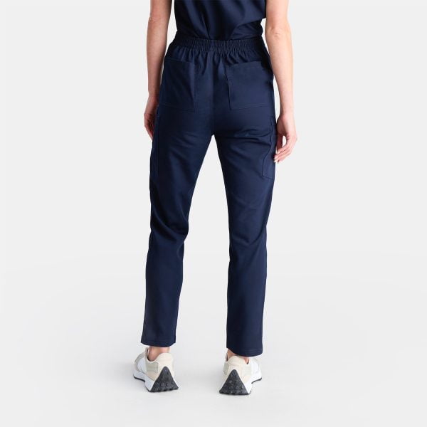 Back View of a Woman Wearing Our Best-selling Modern Twilight Navy Pants. These Straight Leg Style Pants Are Popular Among Our Customers and Feature Five Deep Pockets, Providing Convenient Storage for Nurses on the Go.