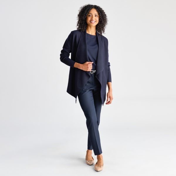 Full-body Shot of a Woman Standing Confidently in a French Navy Milano Knit Waterfall Cardigan, Complete with Tapered Trousers and Beige Shoes.