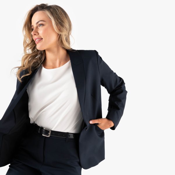 a Confident Woman Posing in a Stylish Navy Blazer over a White Top, Complemented by a Sleek Black Belt.