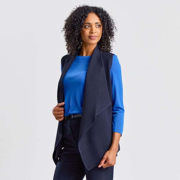 Side View of a Women's Milano Knit Waterfall Vest in French Navy, Draped Elegantly over a Vibrant Blue Top, Creating a Sophisticated and Fluid Silhouette.