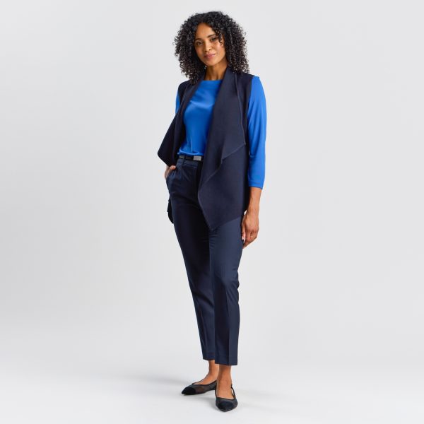 Full-length Portrait of a Woman in a Women's Milano Knit Waterfall Vest in French Navy, Paired with a Bright Blue Top and Navy Trousers, Finished with Black Ballet Flats for a Smart Casual Look.