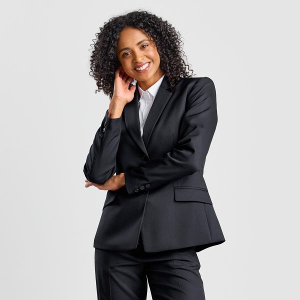 Smiling Woman with Curly Hair, Touching Her Face, Wearing a Black Classic 2-button Blazer over a White Shirt.
