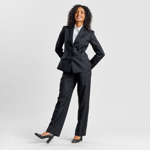 Full-body Shot of a Woman Standing with One Hand on Her Hip, Wearing a Black Classic 2-button Blazer, Trousers, and Heels.