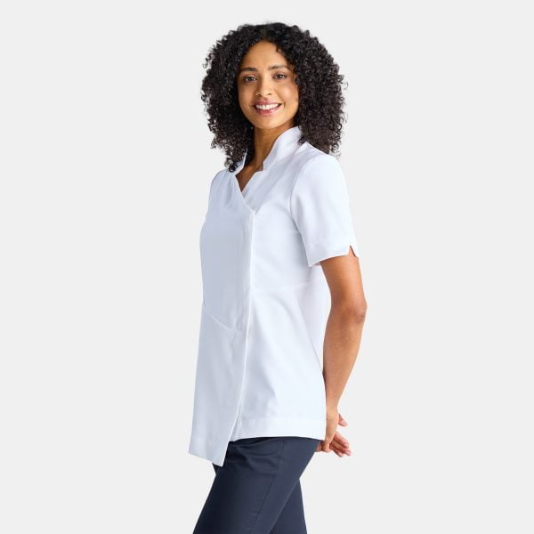 Side View of a Woman Wearing a White Asymmetric Pharmacy Jacket with Short Sleeves, Paired with Navy Pants.