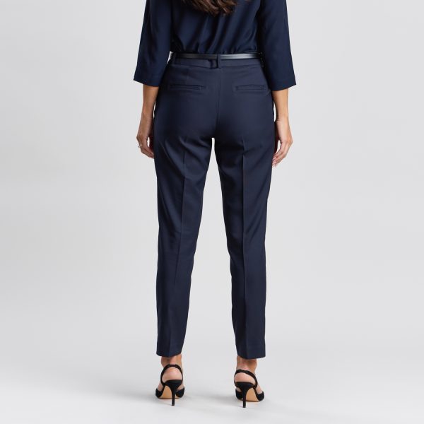 Back View of a Woman Wearing French Navy Cropped Slim Leg Pants with Black Heels, Showcasing the Fit and Pockets.