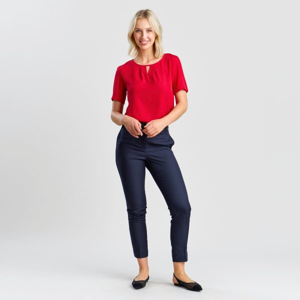 Full-length Portrait of a Woman in Women's Slim Style Chino Pant in French Navy, Matched with a Bright Red Top and Black Flats, Exuding a Mix of Comfort and Sophistication.