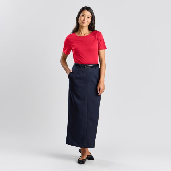 Woman in a Ruby Soft Knit Boat Neck Top and Navy Skirt, with a Hand on Her Hip, Smiling Gently.