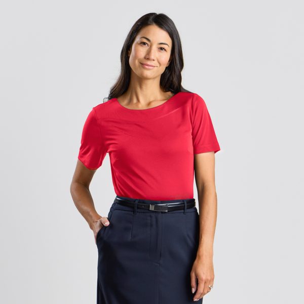 Close-up Front View of a Woman Smiling in a Ruby Soft Knit Boat Neck Top, Tucked into a Navy Skirt.
