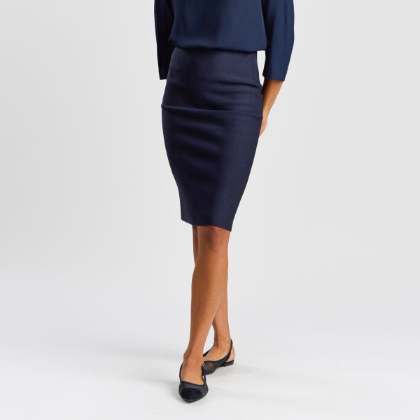 a Woman Standing, Showcasing a French Navy Milano Knit Pencil Skirt Paired with a Matching Top and Black Ballet Flats Against a White Backdrop.