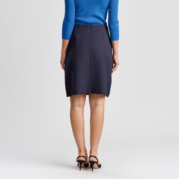 Rear View of a Woman Wearing a Navy A-line Skirt with Pockets, Paired with a Marine Blue Top and Black Heels, Showcasing the Skirt's Elegant Silhouette and Functional Design.