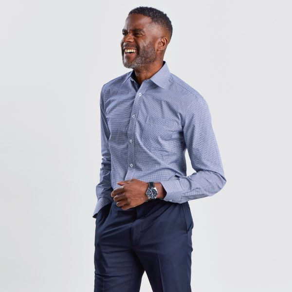 Angled View of a Laughing Man in a Men's Slim Fit Shirt with Long Sleeves in Navy Mini Check, Paired with Dark Trousers for a Sharp Business Casual Look.