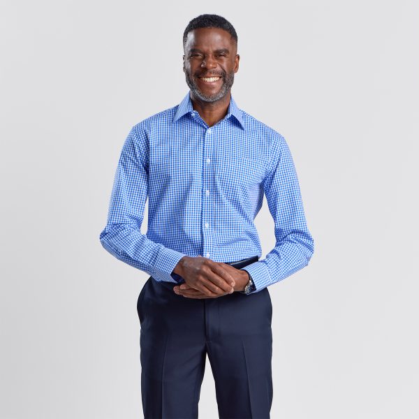 Front View of a Smiling Man Wearing a Blue Checkered Long Sleeve Shirt Tucked into Navy Trousers.