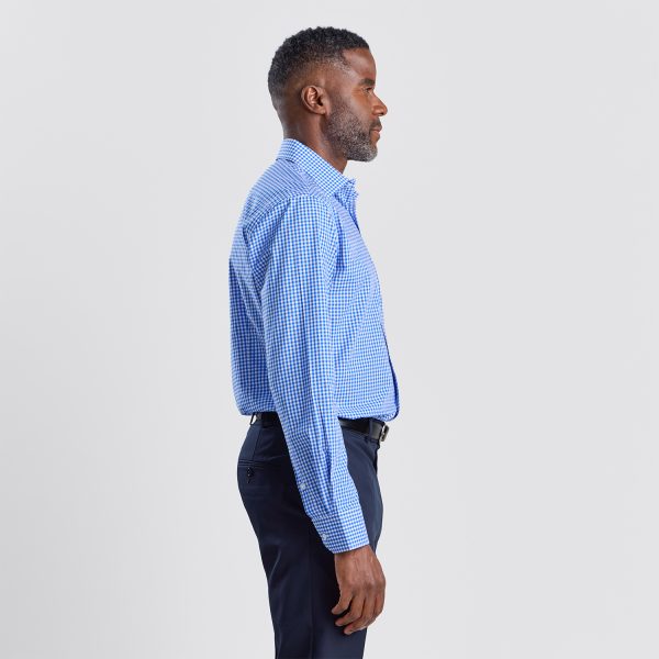 Side View of a Man Wearing a Blue Checkered Long Sleeve Shirt Tucked into Navy Trousers.