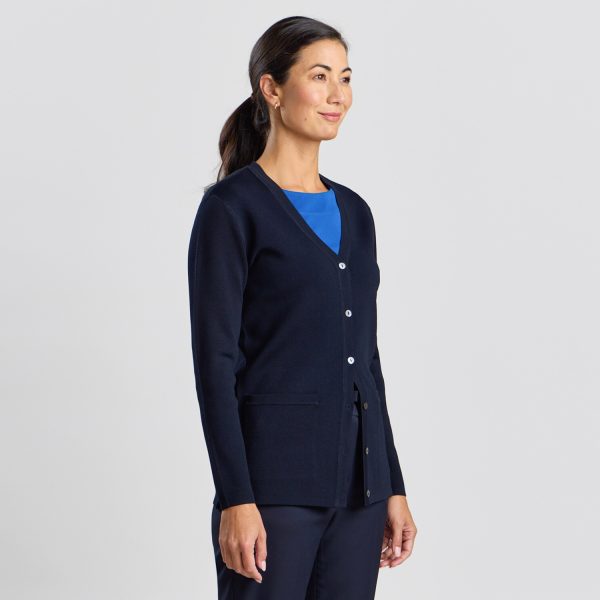 Side Profile of a Woman in a French Navy Milano Knit Button Front Cardigan with Blue Top Underneath and Matching Trousers.
