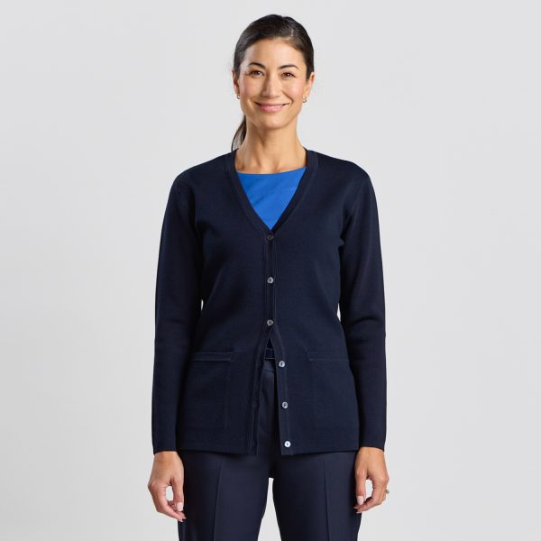 Woman Smiling at the Camera, Wearing a French Navy Milano Knit Button Front Cardigan, with a Bright Blue Top and Navy Trousers.