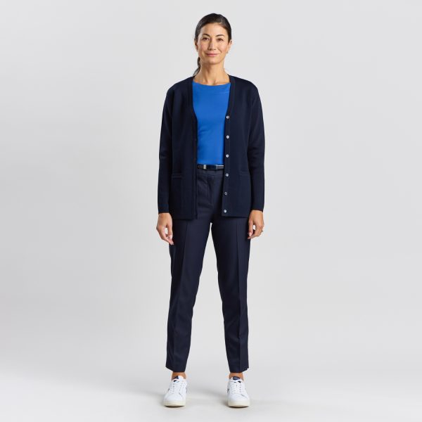 Full-length Image of a Woman in a French Navy Milano Knit Button Front Cardigan, Paired with Navy Trousers and White Sneakers.