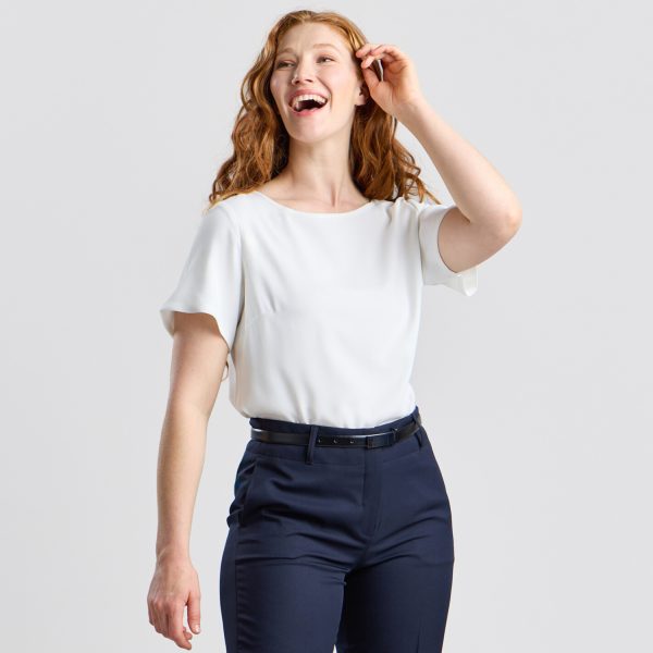 Model in Ivory Bell Sleeve Blouse, Angled to the Side, Against a Light Background, Paired with Navy Trousers.