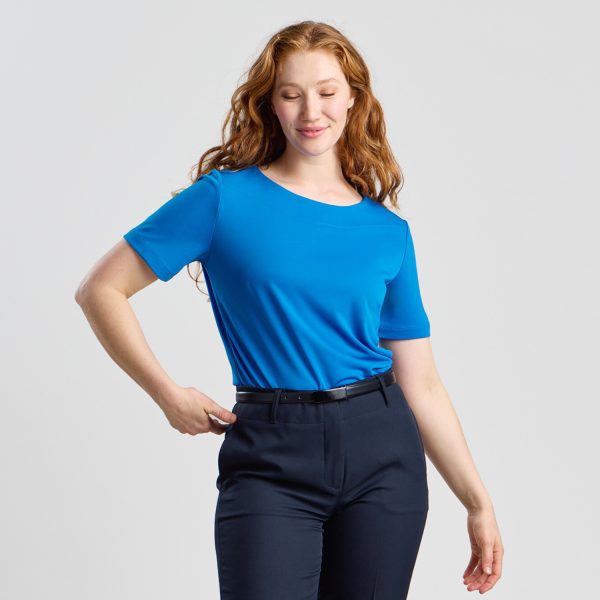 the Model Turned at a 45-degree Angle, Smiling in a Marine Soft Knit Boat Neck Top with Navy Trousers.