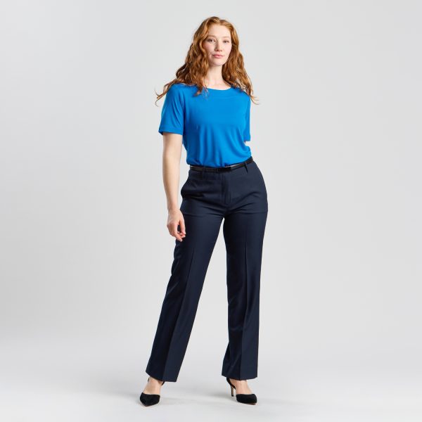 Full Stance of a Model Wearing a Marine Soft Knit Boat Neck Top, Styled with Navy Trousers and Black Heels.