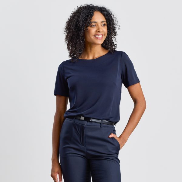 a Model Poses at a 45-degree Angle in a Navy Soft Knit Boat Neck Top with Navy Trousers.
