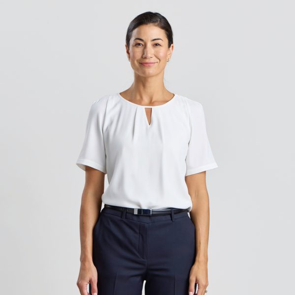Front View of a Smiling Model in an Ivory Keyhole Blouse with Short Sleeves, Styled with Navy Trousers.
