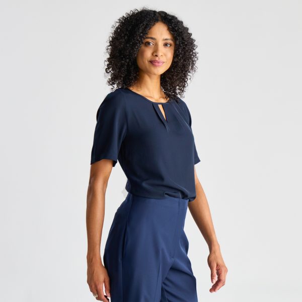Model Turned Away, Displaying the Back of a Navy Keyhole Blouse with Short Sleeves, Paired with Navy Trousers.