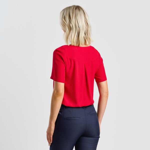 Rear View of a Model Wearing a Short-sleeved Ruby Keyhole Blouse, Worn with Navy Trousers.