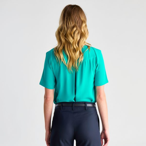 Back View of a Short-sleeved Teal Keyhole Blouse, Tucked into Navy Trousers.