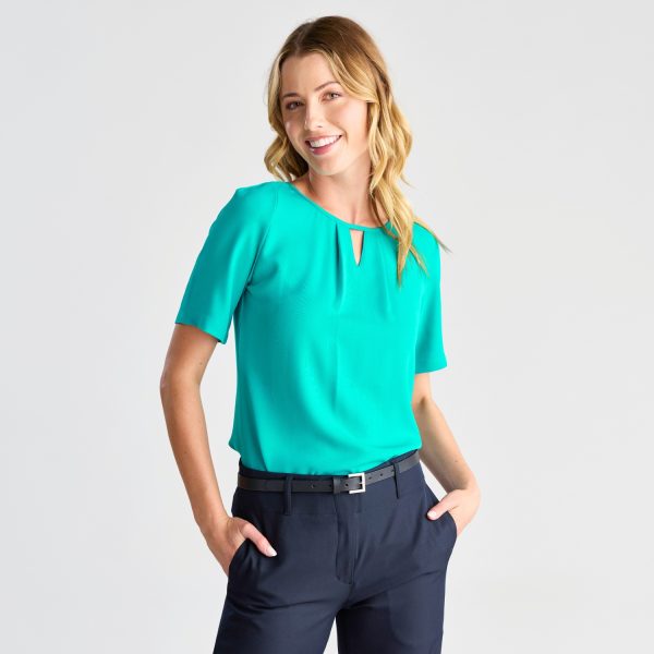 Smiling Model in a Teal Keyhole Blouse with Short Sleeves, Styled with Navy Trousers.