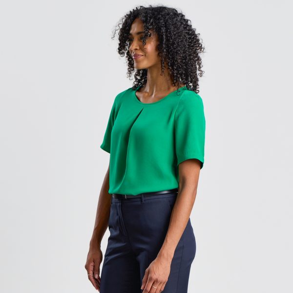 Side Profile of a Model in an Emerald Green Blouse Tucked into Navy Trousers, Focusing on the Garment's Side Fit.