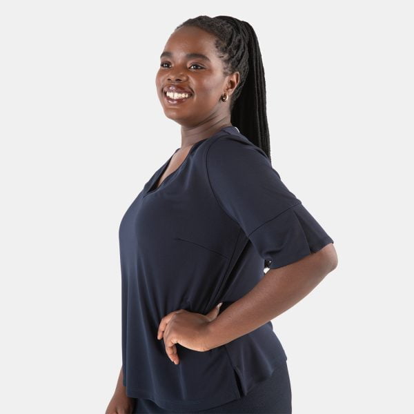 a Smiling Woman Wearing a Navy Short Sleeve V-neck Top in Soft Knit. the Flowy Women's Blue Work Shirt is Comfortable and Flattering.
