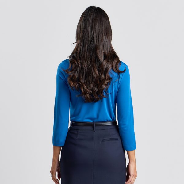 Rear View of a Woman in a Marine Blue Soft Knit 3/4 Sleeve Boat Neck Top with Her Hair Cascading in Waves Down Her Back, Paired with a Navy Skirt.