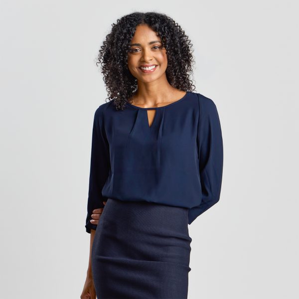 a Beaming Model Wears a Navy Keyhole Blouse with 3/4 Sleeves, Matched with a Navy Skirt.