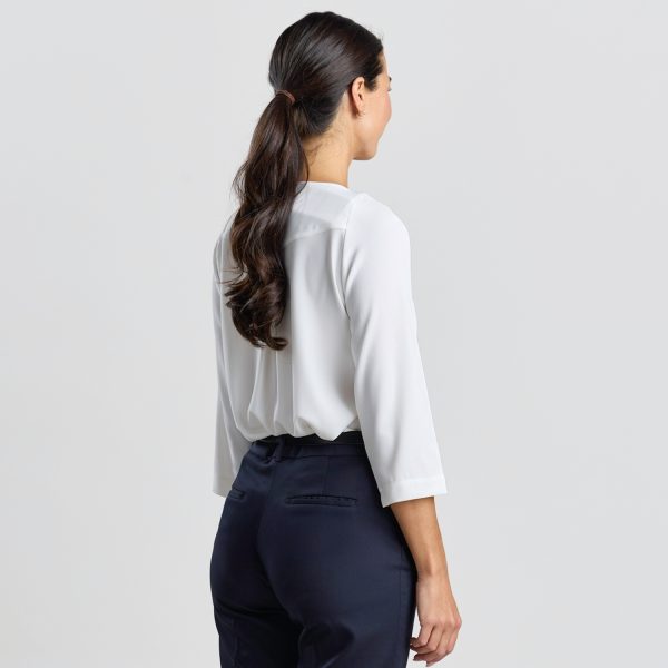 Rear View of a Model in an Ivory Keyhole Blouse with 3/4 Sleeves and Navy Trousers.