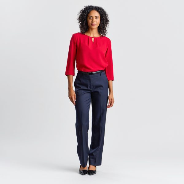 a Model Presents a Ruby Keyhole Blouse with 3/4 Sleeves and Navy Trousers Against a White Background.