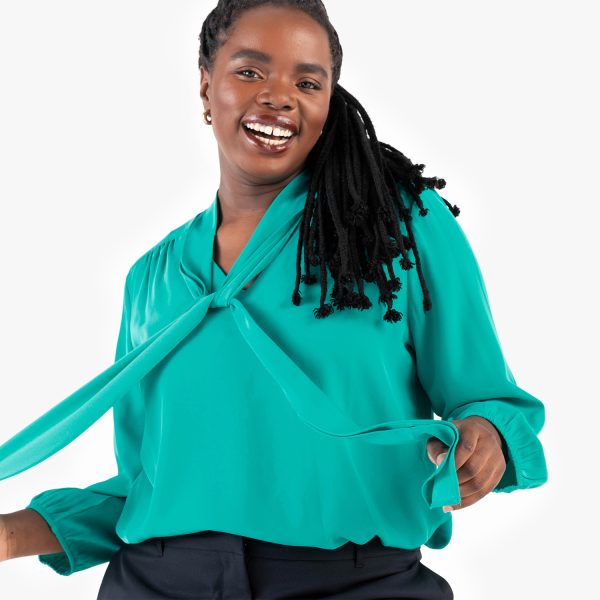 a Joyful Woman in a Teal V-neck Tie-front Blouse with Long Sleeves, Styled with a Side Tie.