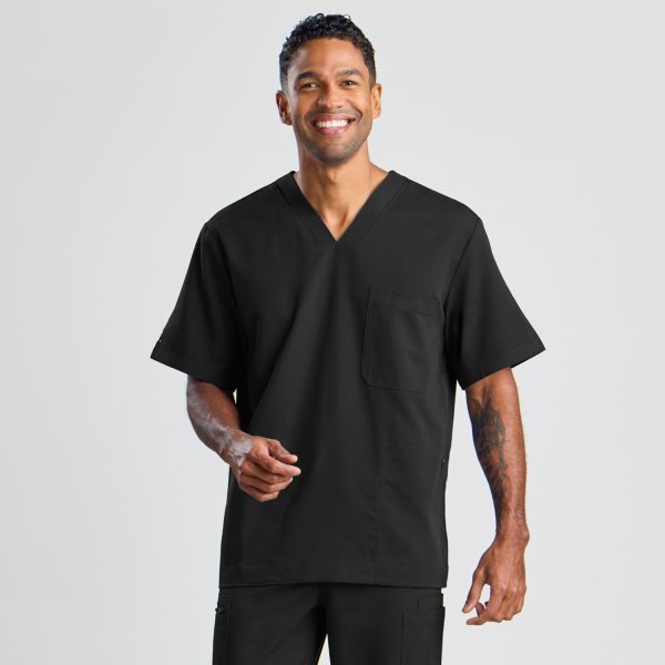 Front View of a Man in the Men's Modern Scrub Top in Classic Black, Featuring a V-neck and a Left Chest Pocket, with a Confident Smile.