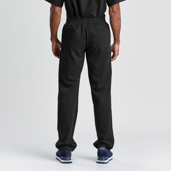 Rear View of Men's Modern Scrub Pant in Black, Emphasizing the Utilitarian Design with Secure Back Pockets and Relaxed Fit, Paired with Navy Blue Athletic Shoes.