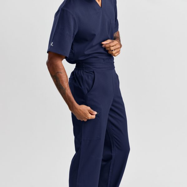 Side Angle View of Men's Modern Scrub Pant in Twilight Navy, Displaying the Pant's Spacious Pockets and Flexible Waistband, Perfect for Healthcare Professionals on the Move.