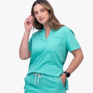 Woman Wearing a Cool Mint Wrap-style Scrub Top with Short Sleeves, a Chest Pocket, and Two Front Patch Pockets, Paired with Matching Drawstring Scrub Pants.