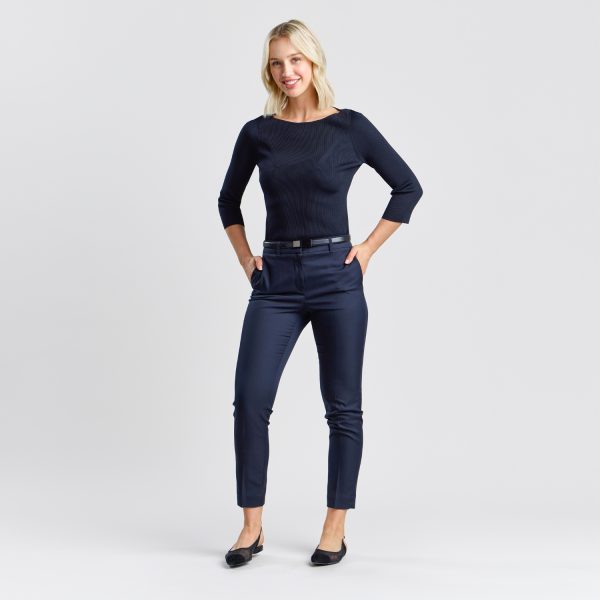 Full-length Portrait of a Woman Wearing a Women's Rib Knit Boat Neck Top in French Navy, Complemented by Slim-fit Navy Pants and Black Flats, Suitable for Both Office and Casual Settings.