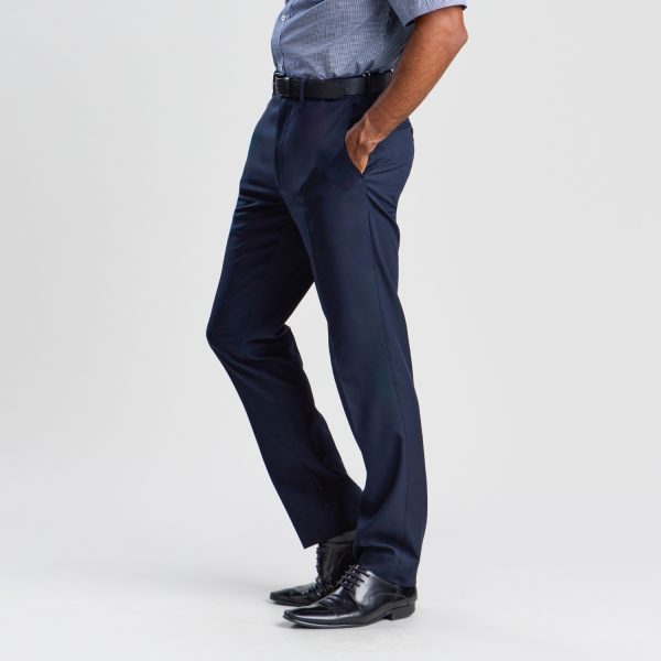 a Side View of a Person Wearing French Navy Slim Fit Business Pants and Polished Black Shoes, Paired with a Grey Belt and Blue Button-up Shirt, Against a White Background.